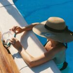 A man sitting on the side of a swimming pool next to an inflatable